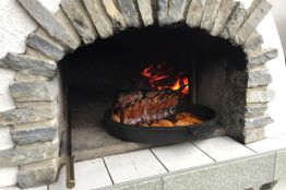 Feine Pizza oder zartes Fleisch aus Pizzaofen geniessen mit Aussicht auf die Berge